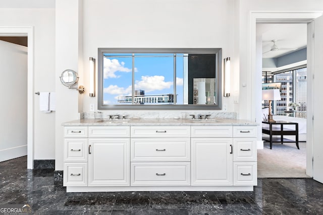 bathroom featuring double vanity, a ceiling fan, and a sink