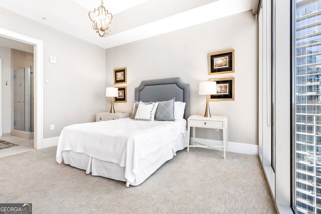 bedroom with a tray ceiling, baseboards, light colored carpet, and an inviting chandelier