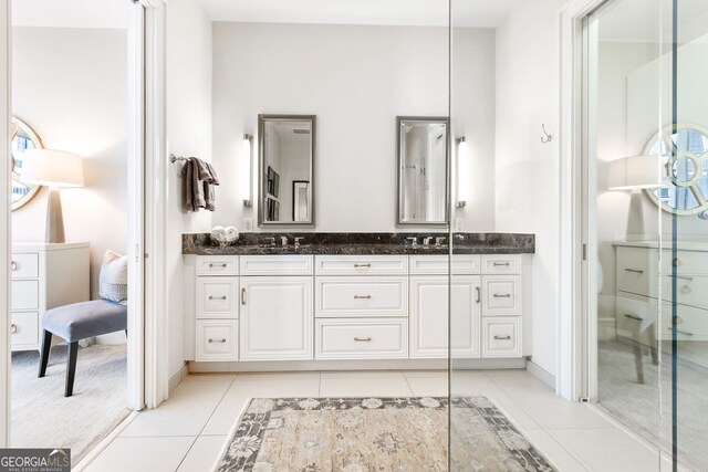 bathroom featuring tile patterned floors, double vanity, and a sink