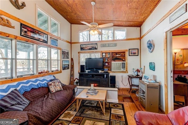 living room with a towering ceiling, wooden ceiling, wood-type flooring, and ceiling fan