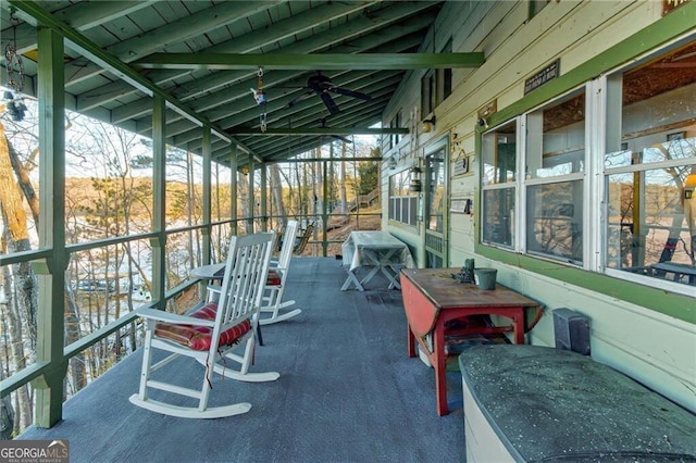 sunroom / solarium with a ceiling fan, a wealth of natural light, and lofted ceiling