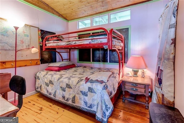 bedroom with vaulted ceiling, wood-type flooring, and wood ceiling