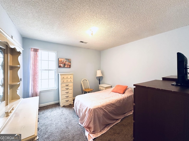 carpeted bedroom with a textured ceiling, visible vents, and baseboards