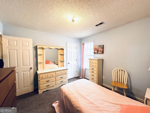 bedroom featuring a textured ceiling, dark colored carpet, visible vents, and baseboards