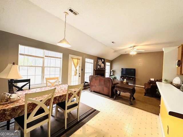 dining area with vaulted ceiling, a textured ceiling, visible vents, and tile patterned floors