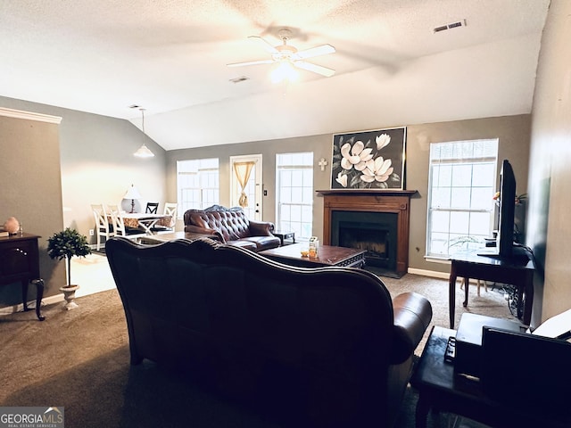 living room with lofted ceiling, visible vents, a fireplace, and carpet flooring