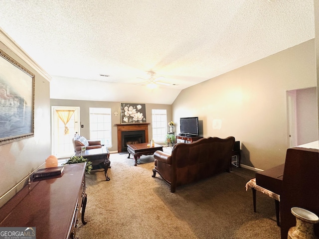 carpeted living room with ceiling fan, a textured ceiling, a fireplace, and baseboards