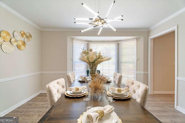 dining area featuring ornamental molding, wood finished floors, and a notable chandelier