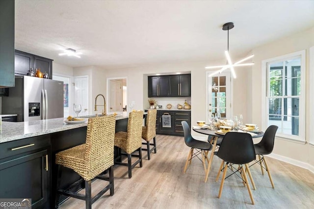 dining area featuring light wood-type flooring and baseboards