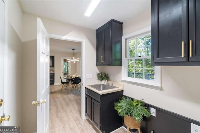 kitchen with light wood-type flooring, light countertops, and a sink