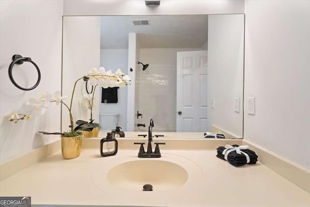 bathroom featuring toilet, visible vents, a shower, and vanity