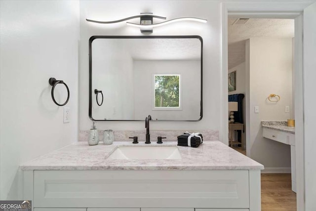 bathroom featuring a textured ceiling, wood finished floors, and vanity