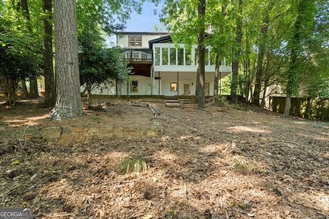 rear view of property featuring a wooden deck