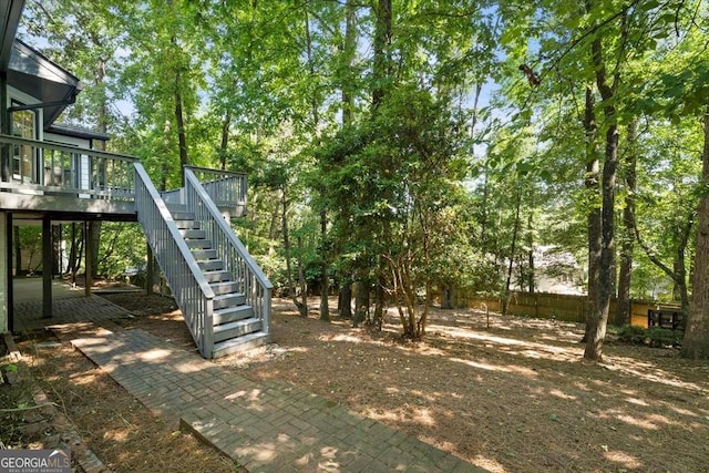 view of yard featuring fence, stairway, and a wooden deck