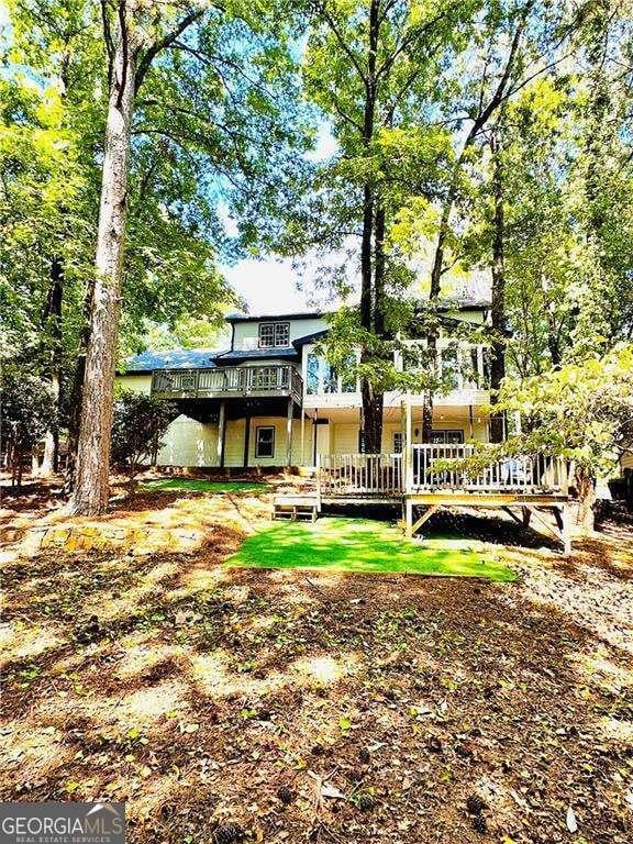 rear view of house with a deck and a yard