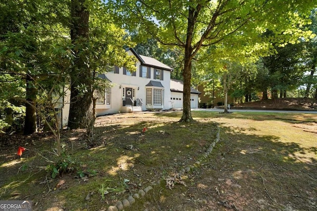 colonial house with a garage and stucco siding