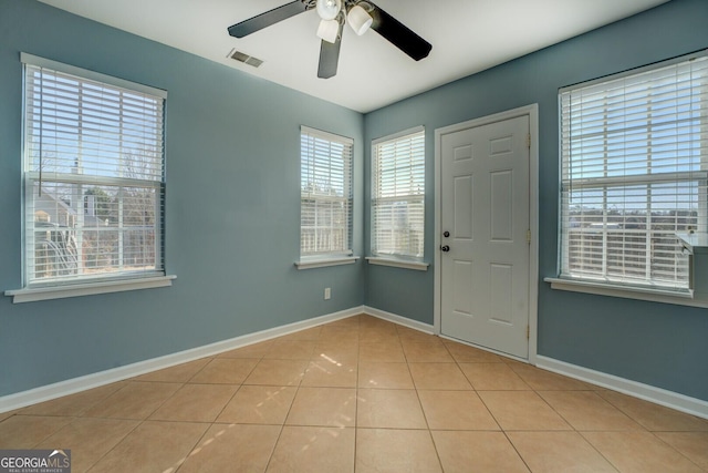 tiled entryway featuring baseboards, visible vents, and a ceiling fan