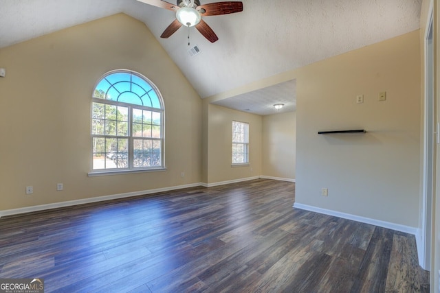 empty room featuring ceiling fan, visible vents, baseboards, vaulted ceiling, and dark wood finished floors