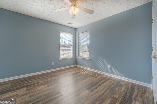 spare room with visible vents, ceiling fan, a textured ceiling, wood finished floors, and baseboards