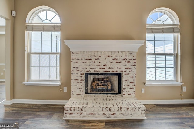 room details with baseboards, a tiled fireplace, and wood finished floors