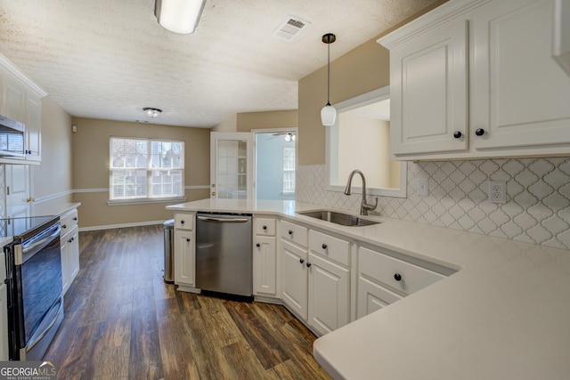 kitchen with visible vents, appliances with stainless steel finishes, dark wood-style flooring, light countertops, and a sink