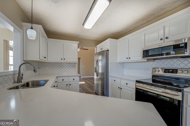 kitchen featuring appliances with stainless steel finishes, a sink, and white cabinetry