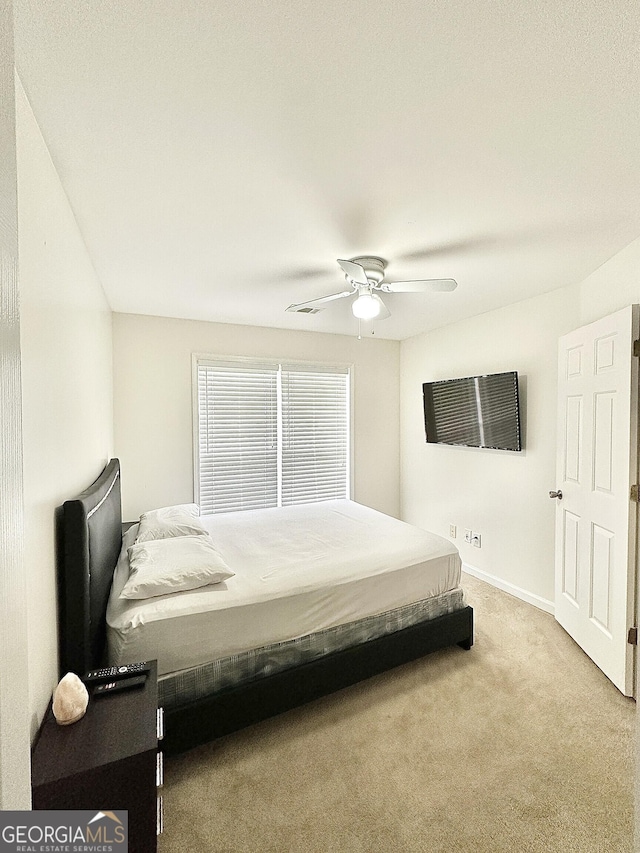 carpeted bedroom featuring a ceiling fan and baseboards