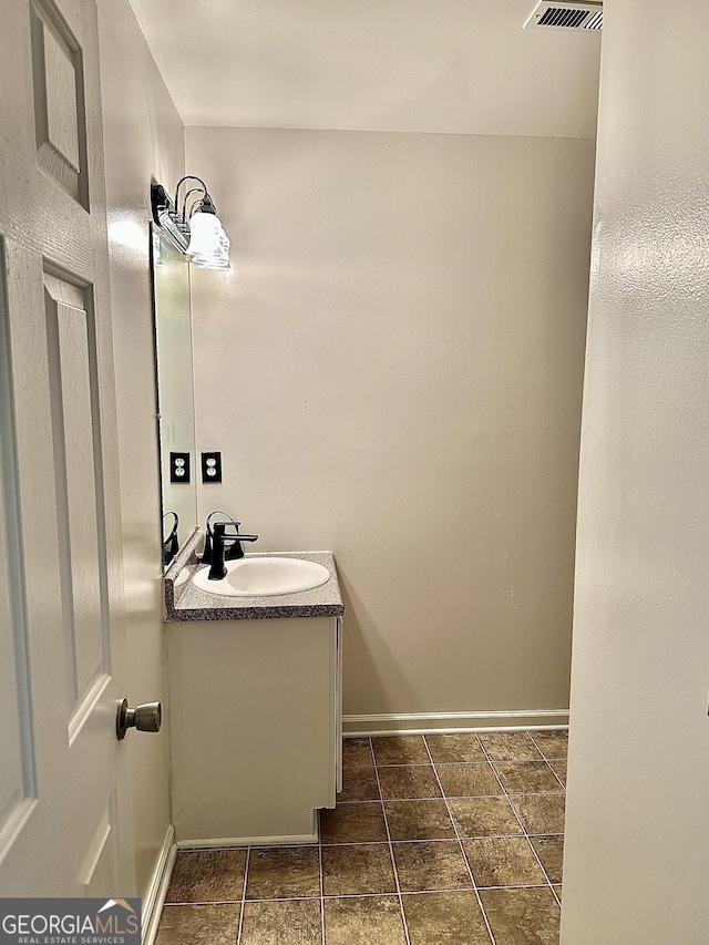 bathroom with visible vents, vanity, and baseboards