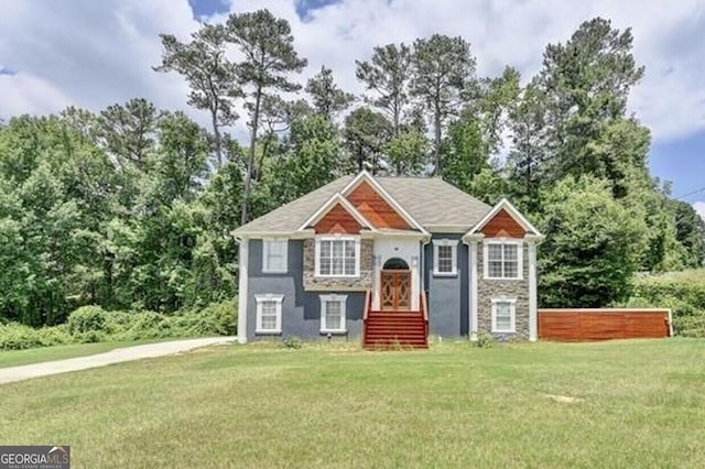 view of front of home with stone siding and a front lawn