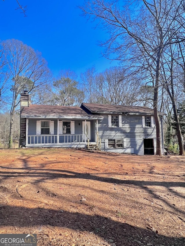 view of front of home featuring a porch and a chimney