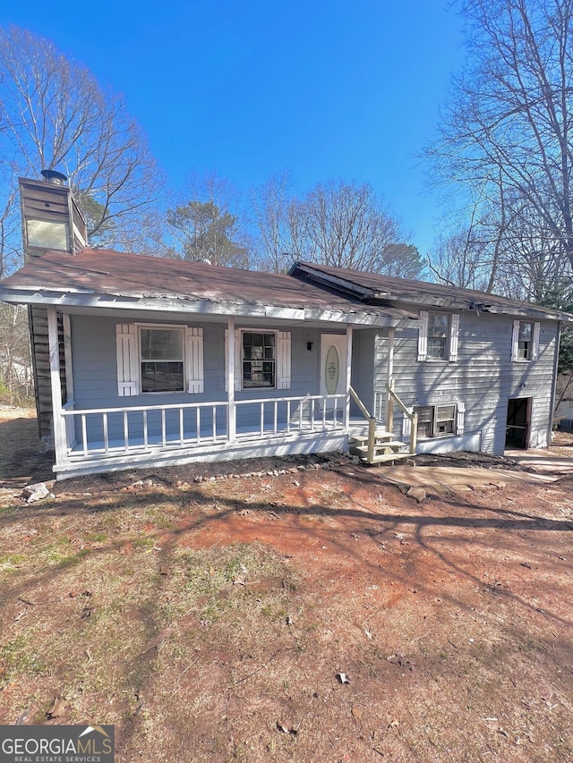 view of front facade with a porch and a chimney