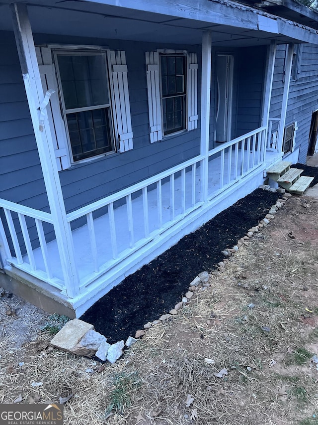 view of side of home featuring covered porch