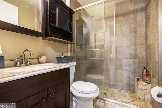 full bath with toilet, a shower stall, and vanity