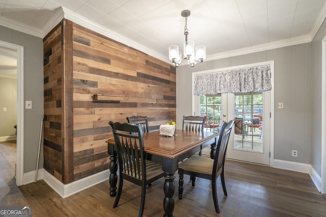 dining area featuring dark wood-style floors, baseboards, a chandelier, and crown molding