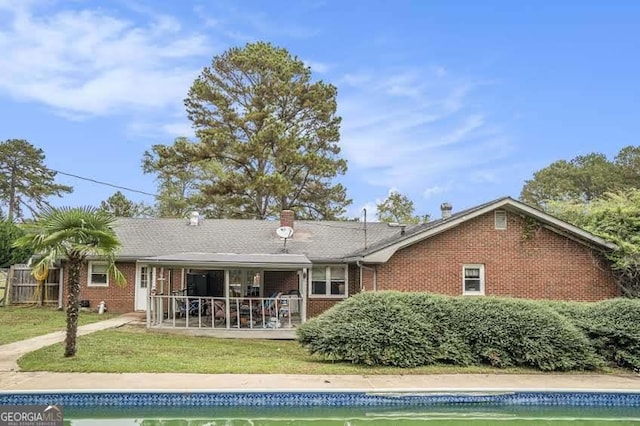 back of house featuring a patio area, brick siding, an outdoor pool, and a chimney