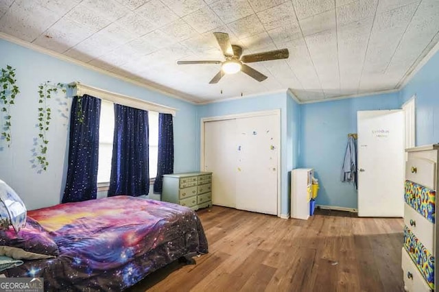 bedroom with ceiling fan, wood finished floors, and crown molding