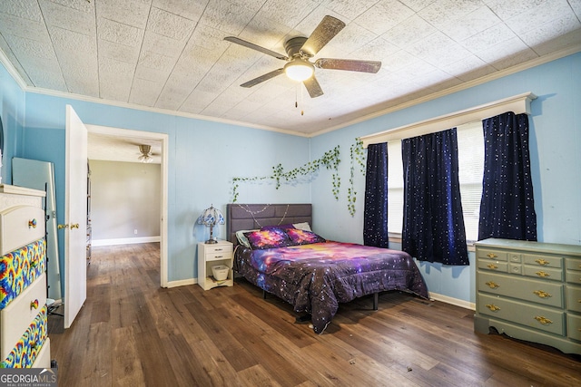 bedroom featuring baseboards, crown molding, and wood finished floors