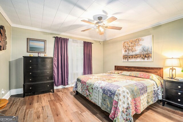 bedroom with crown molding, ceiling fan, and wood finished floors