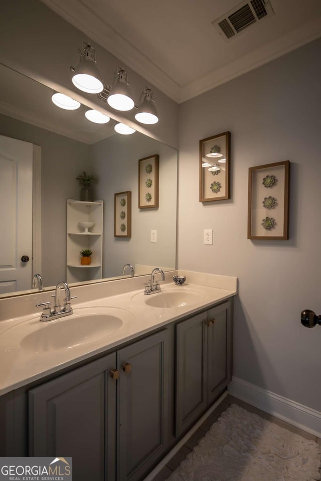 bathroom featuring double vanity, crown molding, visible vents, and a sink