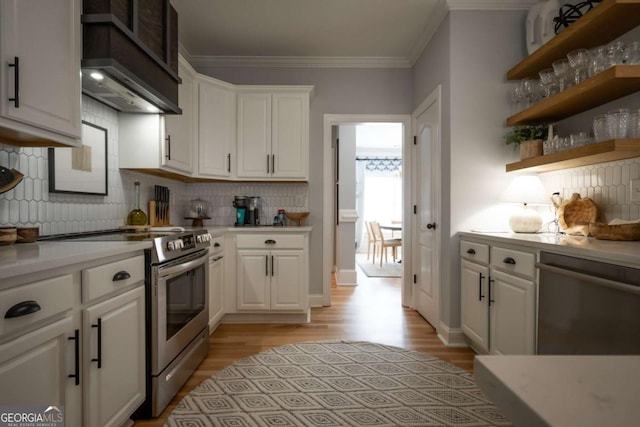 kitchen with white cabinets, appliances with stainless steel finishes, light countertops, and crown molding