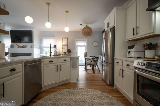 kitchen with stainless steel appliances, light countertops, white cabinetry, and under cabinet range hood