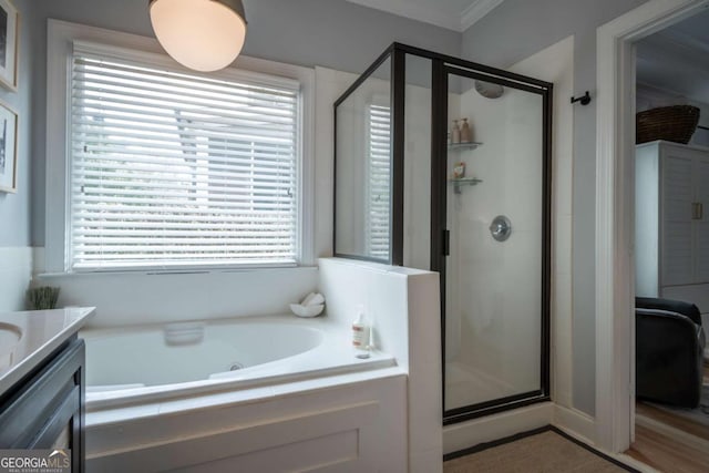 bathroom featuring a stall shower, vanity, and a bath