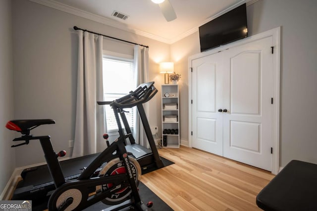 workout room featuring light wood finished floors, visible vents, ornamental molding, a ceiling fan, and baseboards