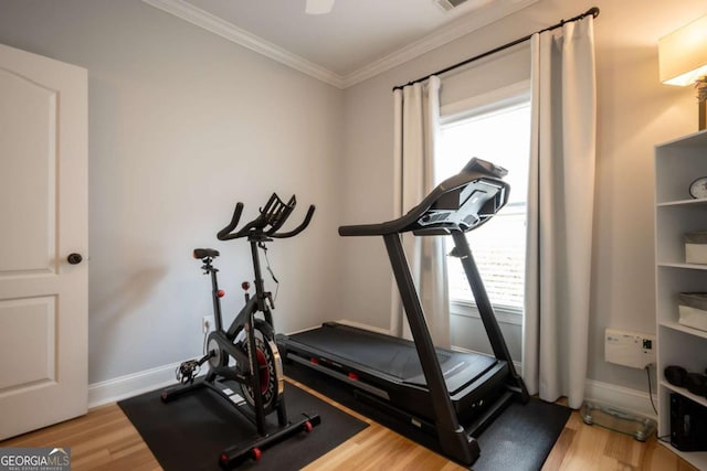 exercise area with baseboards, wood finished floors, and crown molding