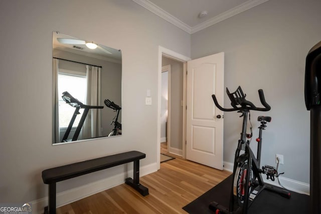 exercise room with crown molding, baseboards, and wood finished floors