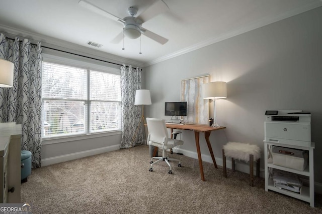 carpeted office with ornamental molding, visible vents, baseboards, and a ceiling fan