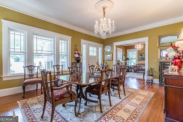 dining room with crown molding, hardwood / wood-style flooring, and a notable chandelier