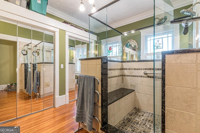 full bath with a shower stall, crown molding, and wood finished floors