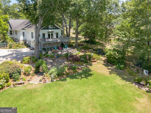 view of yard featuring driveway, a patio area, and a wooden deck