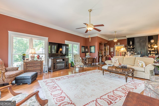 living room featuring ornamental molding, light wood-type flooring, and a ceiling fan